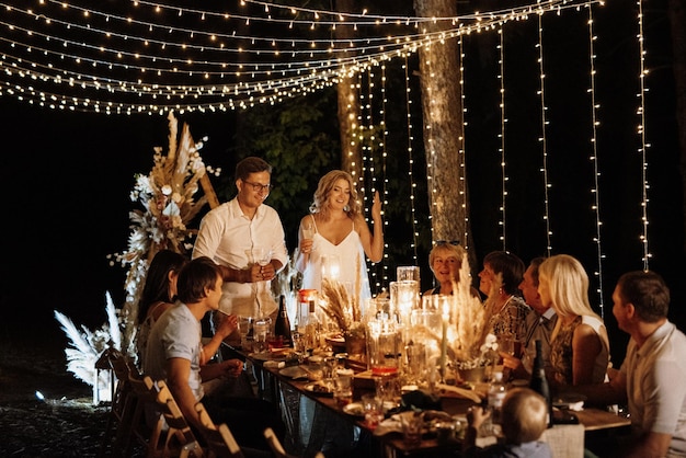 Jantar de casamento em família à noite na floresta