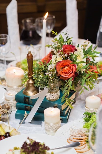 Jantar de casamento no restaurante, mesas decoradas com vasos de rosas.