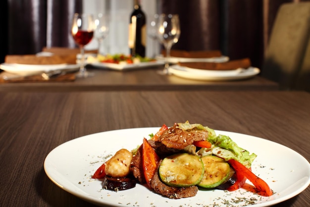 Foto jantar de luxo servido na mesa com copo de vinho tinto