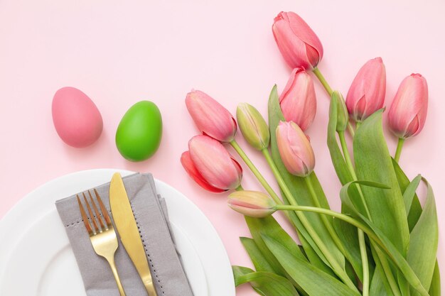 Jantar de Páscoa de ovo e tulipa cor pastel e talheres dourados em rosa