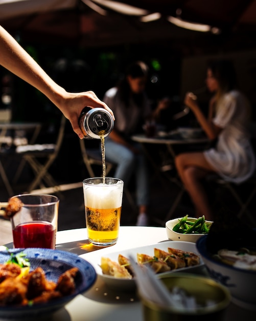 Jantar em esplanada de café com cerveja e comida japonesa