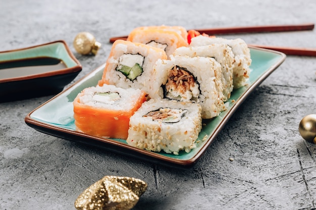 Jantar festivo de Natal com conjunto de sushi e decoração de Natal em fundo de concreto. Festa de Ano Novo.