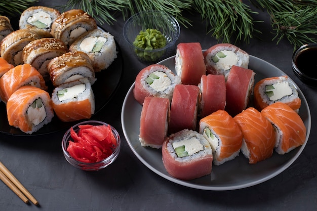 Jantar festivo de Natal com sushi de salmão, atum e enguia com queijo da Filadélfia. Festa de Ano Novo. Close em fundo escuro