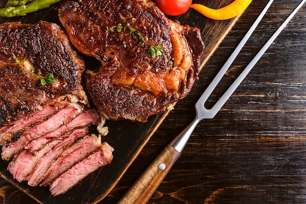 Jantar para dois deliciosos bifes suculentos, aspargos com parmesão e legumes.