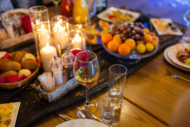 Jantar romântico com vinho e velas na mesa.