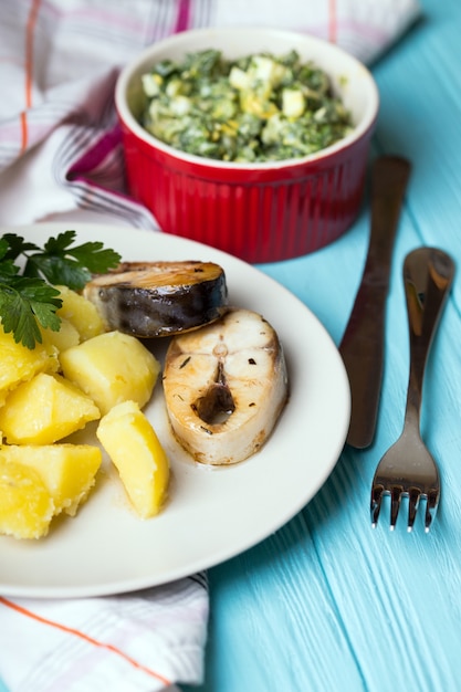 Jantar tradicional escandinavo - batatas cozidas e cavala em um fundo azul