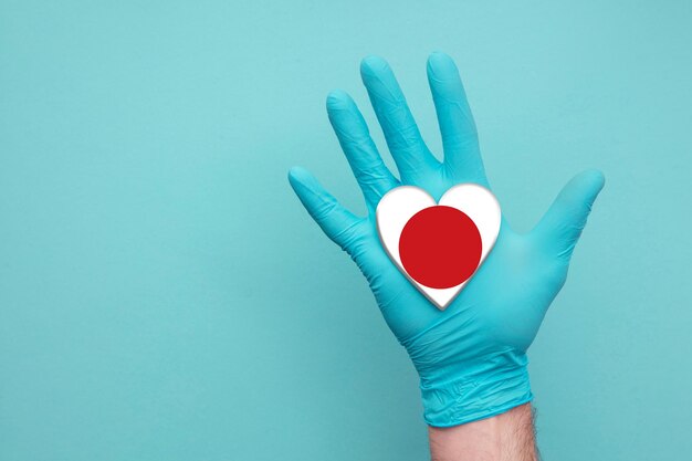 Japan medizinische Gesundheit Herzkrankenschwester Hand hält Land Herz Flagge