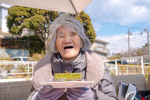 Japanische alte Frau und ein Kuchen