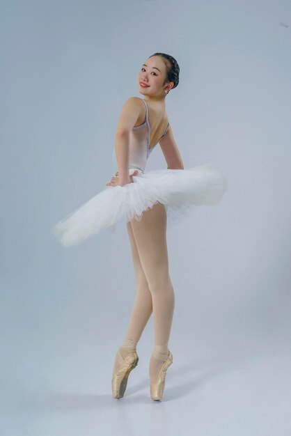 Foto japanische ballerina posiert in einem fotostudio mit ballettelementen, die dehnung und plastizität zeigen