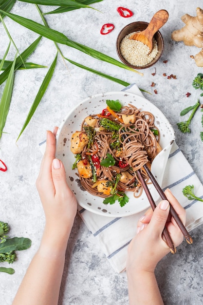 Japanische Buchweizennudeln Yakisoba mit Huhn und Gemüse auf hellem Hintergrund