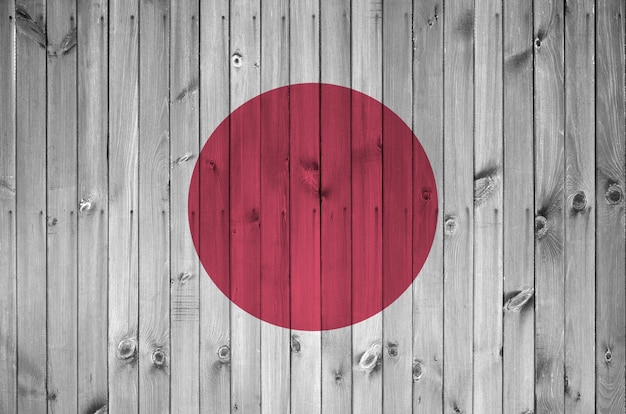 Japanische Flagge in hellen Farben auf alter Holzwand dargestellt. Strukturiertes Banner auf rauem Hintergrund