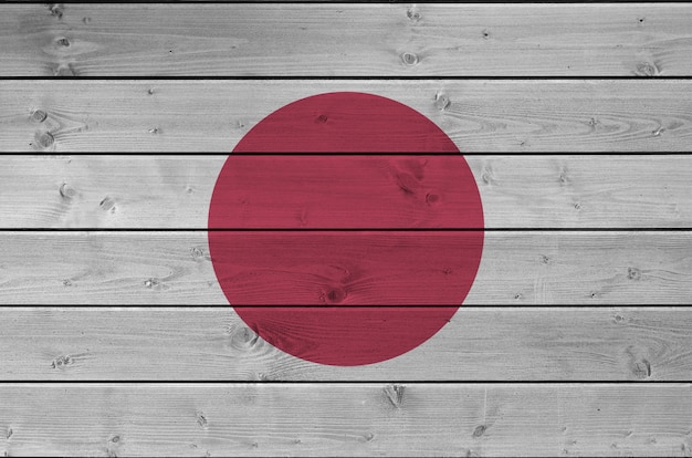 Japanische Flagge in hellen Farben auf alter Holzwand dargestellt.