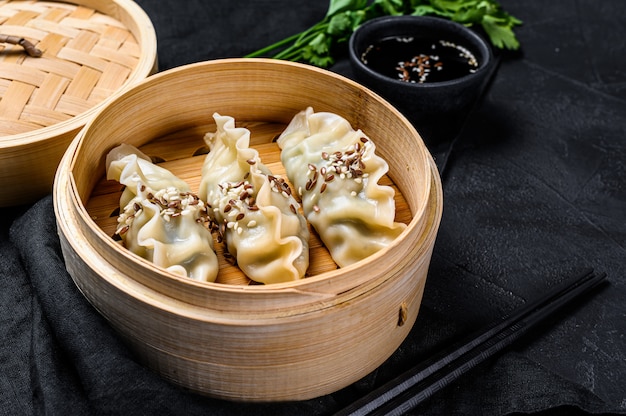 Japanische Gyoza in einem traditionellen Bambusdampfer. Ansicht von oben. Rustikaler alter Jahrgang