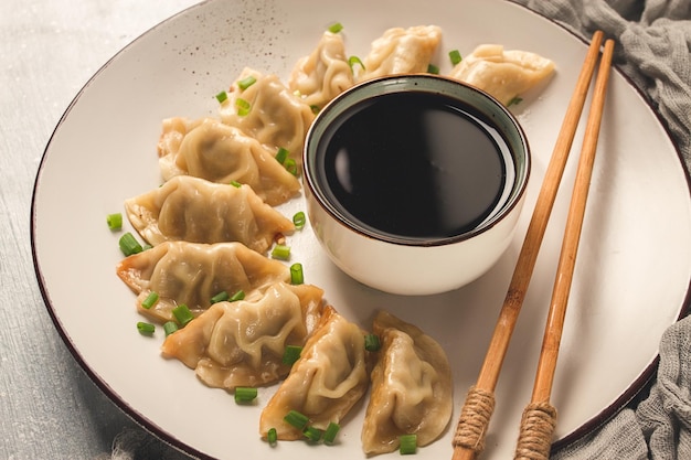 Japanische Gyoza-Knödel, gebraten mit Sauce, Draufsicht, ohne Menschen, getönter selektiver Fokus