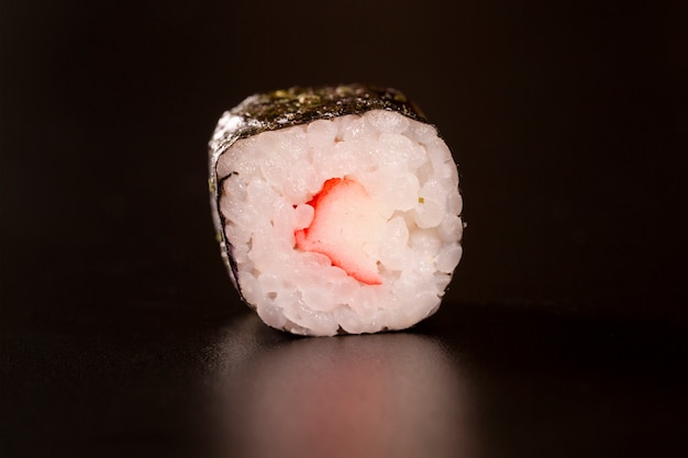 Japanische Küche. Eine Ruhe der Sushi-Rolle lokalisiert auf schwarzem Hintergrund Nahaufnahme Schuss