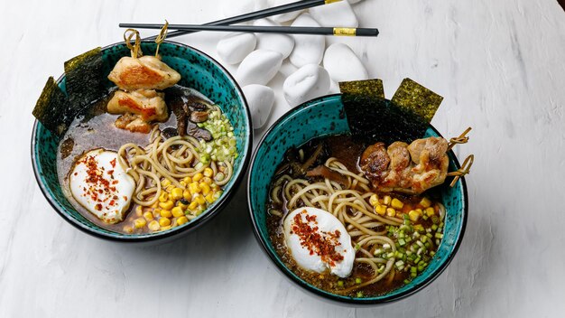 Japanische Küche Ramen-Suppe Nudeln mit Fleisch, Ei und Gemüse auf einem weißen Tisch