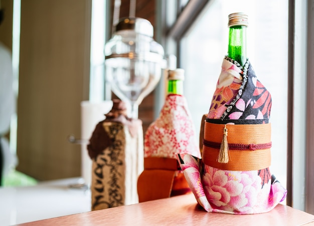 Japanische Sake-Flaschenverpackung mit japanischem Kimono-Stil auf der Omakase-Sushi-Theke