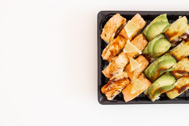 Japanische Sushi-Rollen mit Lachs, Avocado und Garnelen auf Weiß