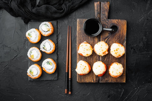 Japanische Sushi-Rollen namens Baked Ebi mit Wasabi und Lachsfisch auf schwarzem Stein