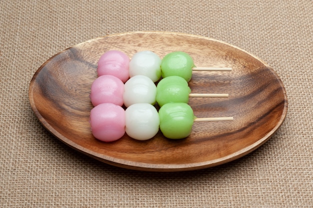 Japanische traditionelle Süßigkeit namens Dango Mochi auf Holzplatte.