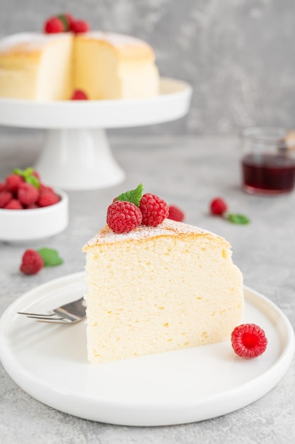 Japanischer Baumwollkäsekuchen auf einem Ständer mit frischen Himbeeren und Puderzucker Kopierbereich