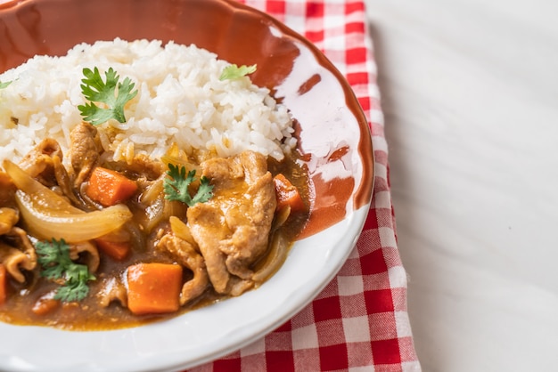 Japanischer curryreis mit geschnittenem schweinefleisch, karotten und zwiebeln