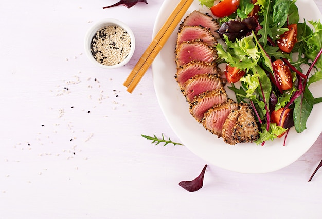 Japanischer traditioneller Salat mit Stücken mittel-seltenem gegrilltem Ahi Thunfisch und indischem Sesam mit Frischgemüsesalat auf einer Platte