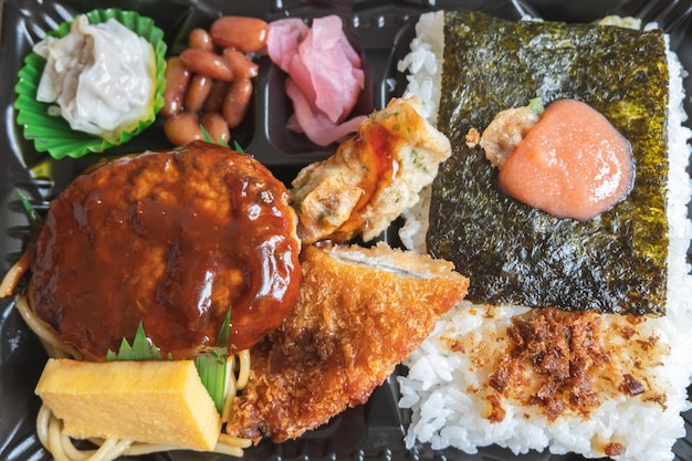 Japanisches Bento-Set, Lunchbox mit Hamburgersteak, Algen auf in Reis gebratenem Fisch und japanischem gerolltem Omelett