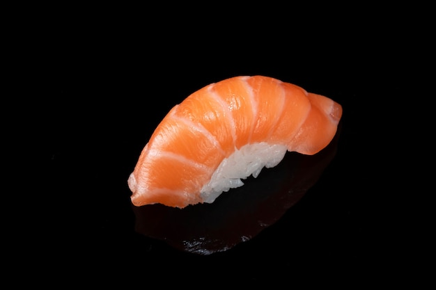 Japanisches frisches Sushi Nigiri mit Lachs lokalisiert auf Schwarz