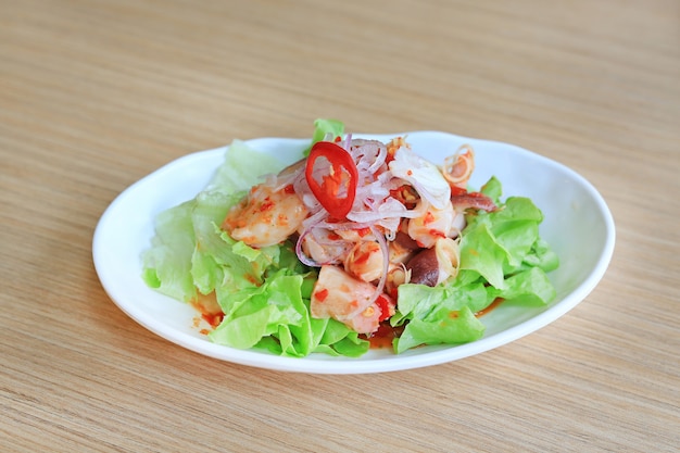 Japanisches lebensmittel, würziger krake tako-salat auf holztisch.
