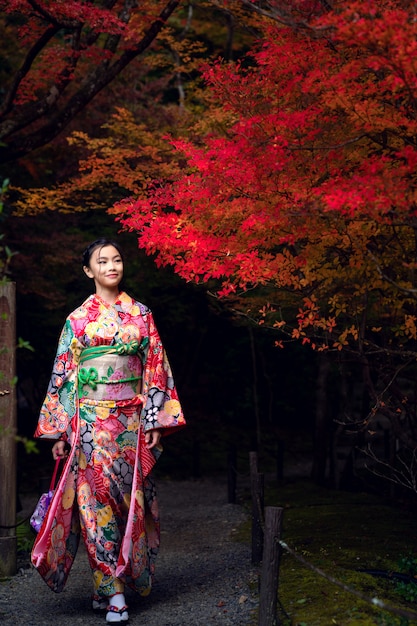 Japanisches Mädchen im traditionellen Kimonokleidspaziergang im alten Kyoto-Tempel