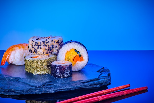 Japanisches Meeresfrüchtesushi gesetzt auf einem Stein auf Blau