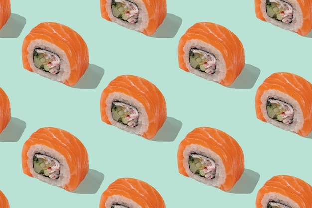 Japanisches Sushi mit Lachsdrachenrollen auf pastellgrünem Hintergrund Hintergrundmuster der Pop-Art