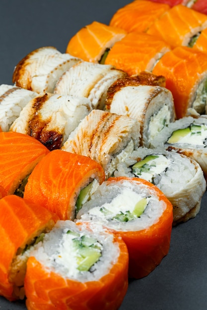 Japanisches traditionelles Essen. Set Sushi-Rollen mit frischer Lachs-Avocado und Frischkäse und Sojasauce