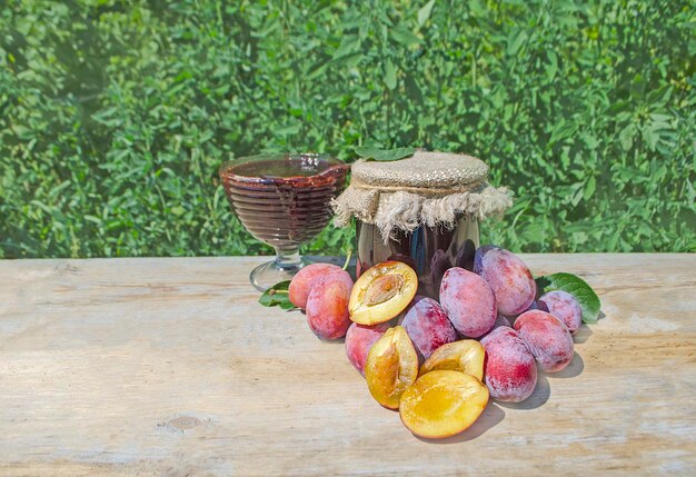 Jar com ameixa fresca sobre fundo de madeira