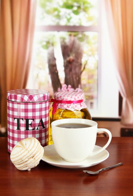 Foto jar y taza de té en la mesa en la habitación