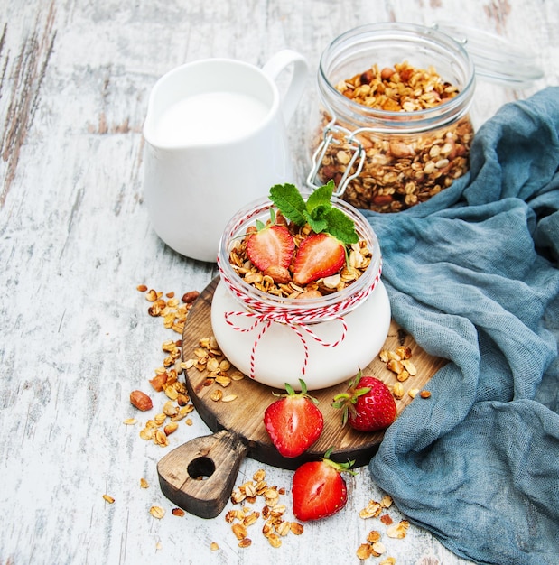 Foto jar con yogur y granola con fresas en una mesa