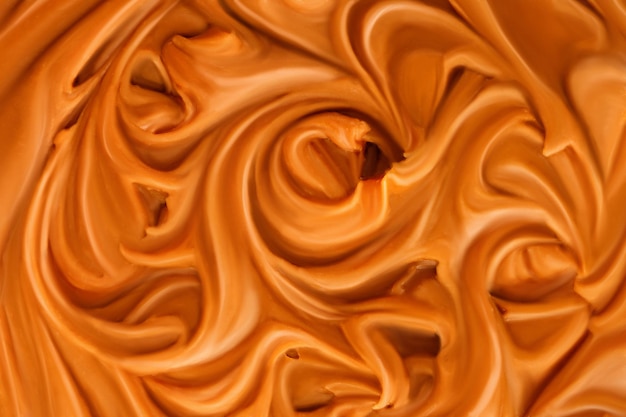 Jarabe de caramelo derretido líquido Fondo de pasta de jarabe de caramelo Onda de rizo de textura de caramelo