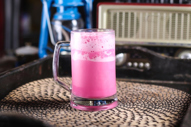 Foto jarabe de leche de rosa o batido de gulab servido en una taza aislada en la vista superior de la alfombra roja en la bebida árabe de mesa