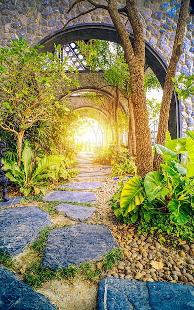 jardim com entrada de arco natural e raios solares, portões mágicos na fabulosa floresta verde