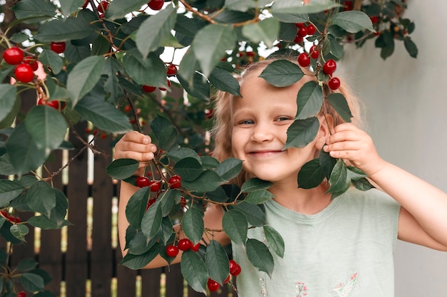 Jardim de cerejeiras e uma menina sorridente olha por trás dos galhos das cerejeiras