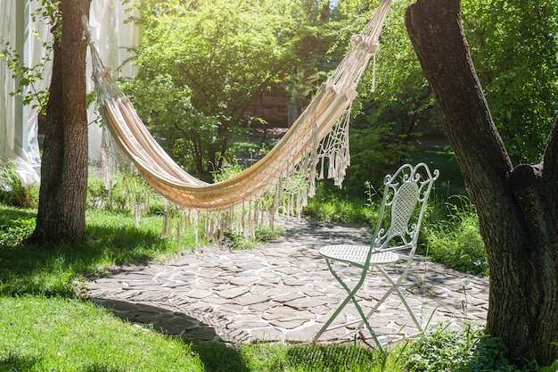 Jardim de verão com rede de suspensão para relaxar.