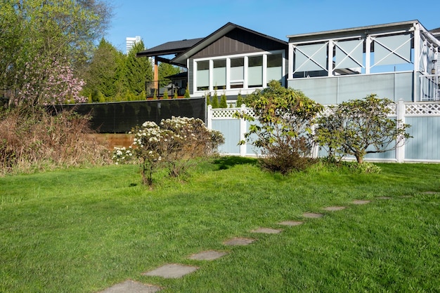 Foto jardim traseiro de uma casa residencial com pátio aberto e gramado verde na frente