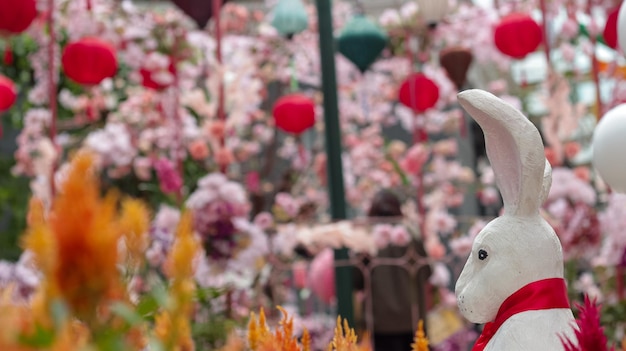 Un jardín chino con una estatua de conejo frente a una exhibición de flores.