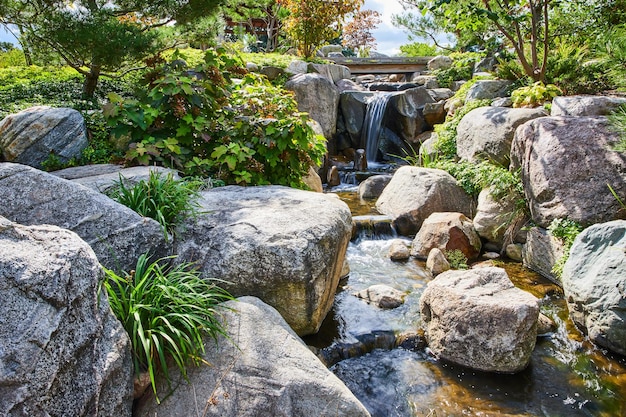 Jardín japonés sereno con cascada y follaje de otoño