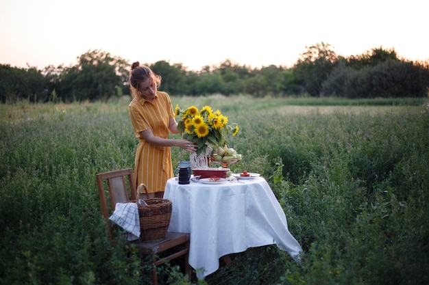 Jardín y naturaleza muerta. Fiesta del té en el jardín - niña y ramo con girasoles en la mesa