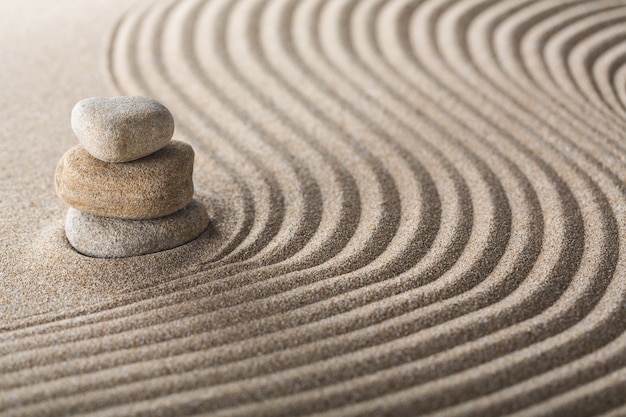 Jardín zen japonés con piedra en arena rastrillada