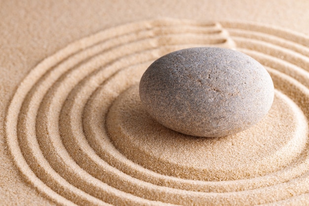 Jardín zen japonés con piedra en arena rastrillada