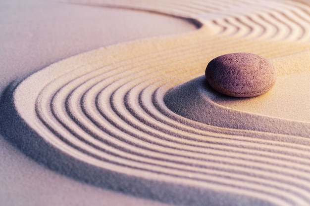 Jardín zen de meditación con piedras sobre arena.