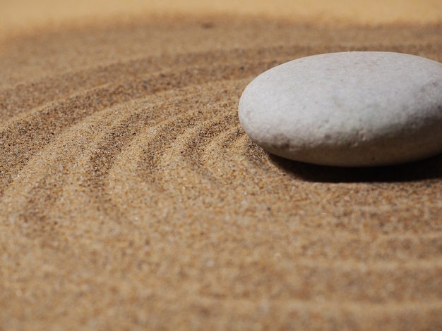 Jardín zen. Pirámides de piedras zen blancas y grises en la arena blanca con dibujos abstractos de ondas.